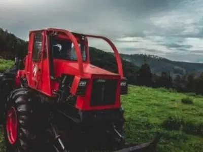 Red tractor with trees behind it